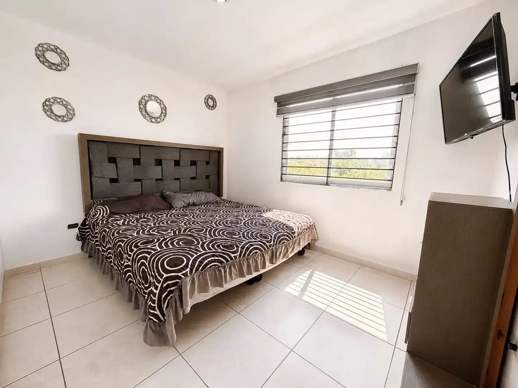 Recámara principal con TV y cabecera departamento Mazatlán