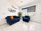Sala con sofá azul departamento en venta Mazatlán