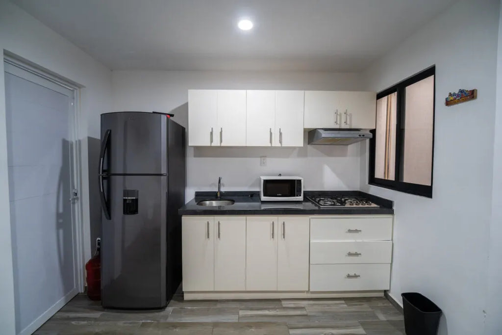 Cocina integral con refrigerador y microondas en departamento en venta en Mazatlán