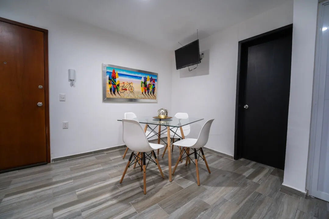 Área de comedor con mesa redonda de vidrio en departamento en Playa Sur Mazatlán