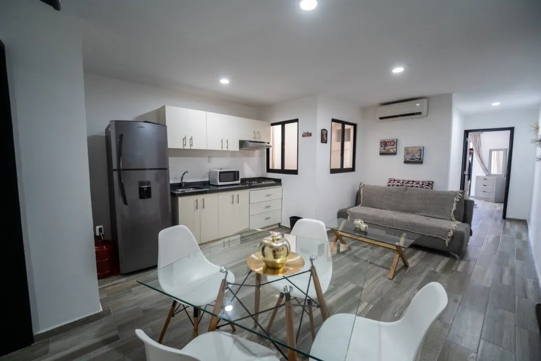 Sala, comedor y cocina de concepto abierto en departamento amueblado en Playa Sur