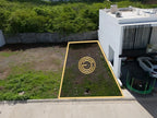 Vista lateral del terreno en venta en Pacífico Hills Mazatlán, junto a casa vecina construida