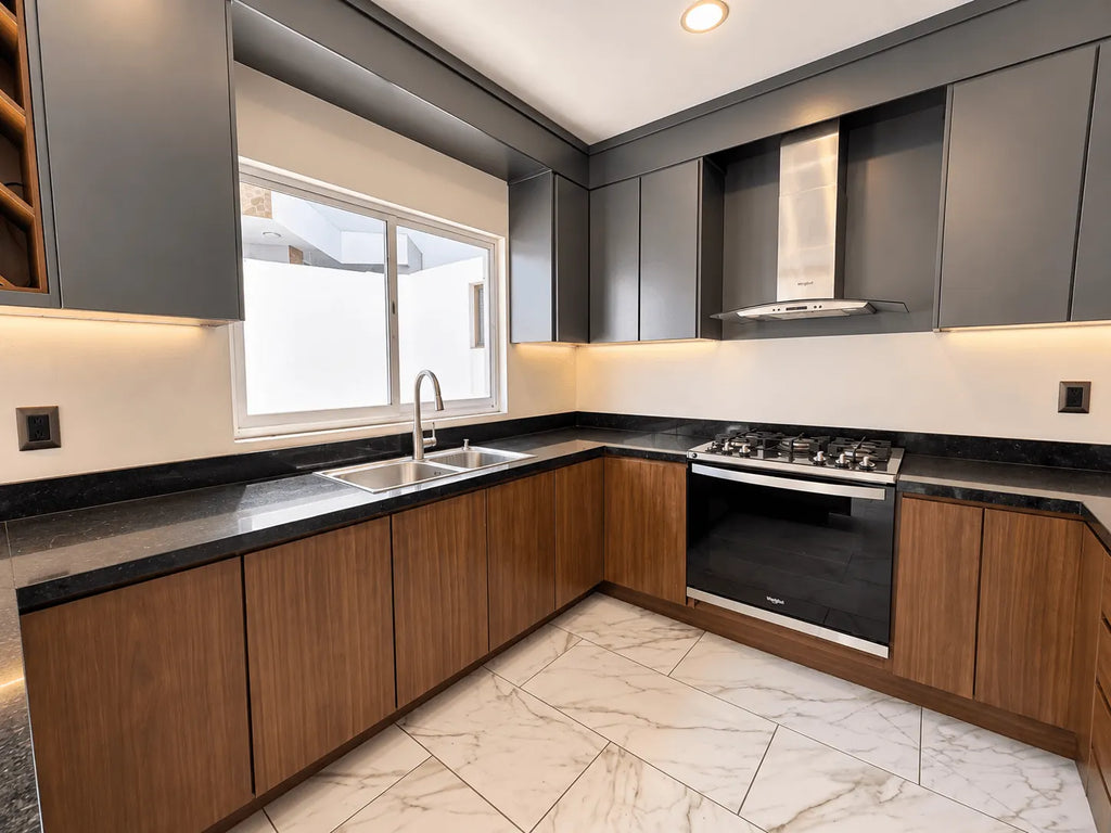 Cocina moderna con gabinetes oscuros, barra y estufa integrada