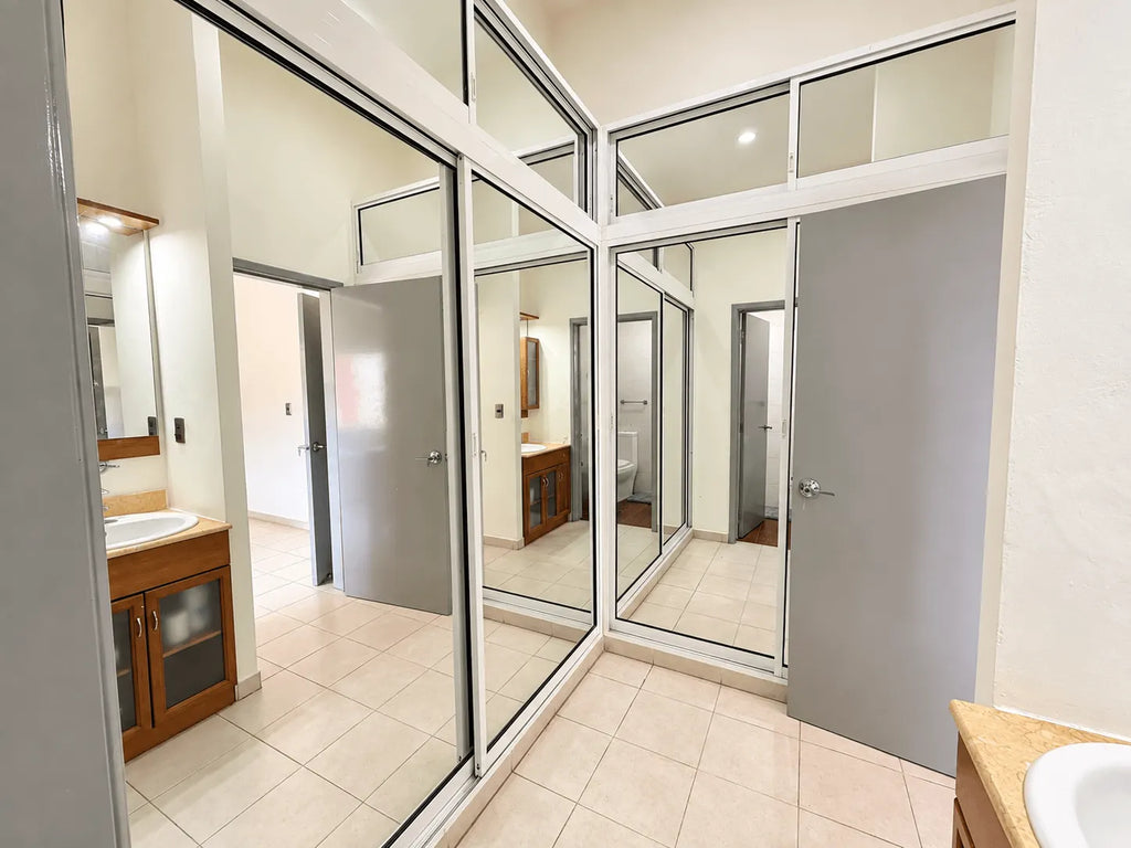 Vestidor con closet espejado en recámara principal