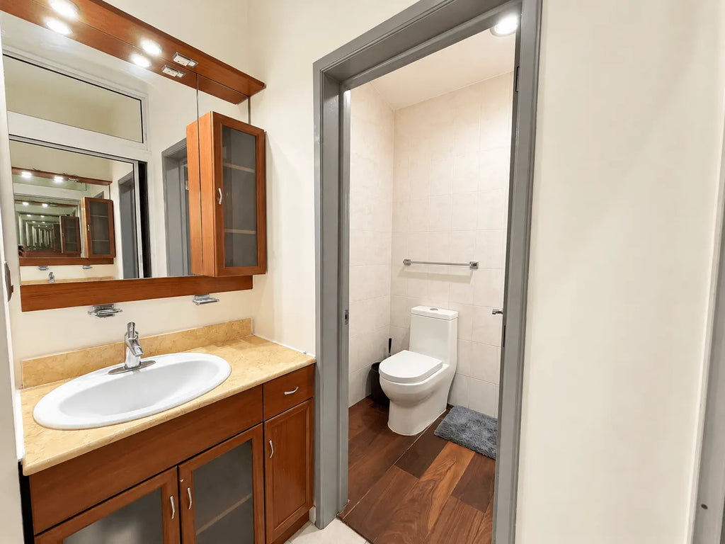 Baño completo con lavabo de madera y regadera independiente