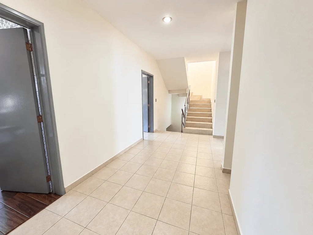 Pasillo interior con piso de mármol junto a la escalera