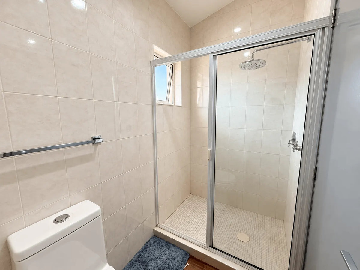 Baño con regadera de cristal templado