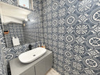 Medio baño con azulejo decorativo y lavabo ovalado