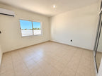 Recámara vacía con ventana y piso de loseta