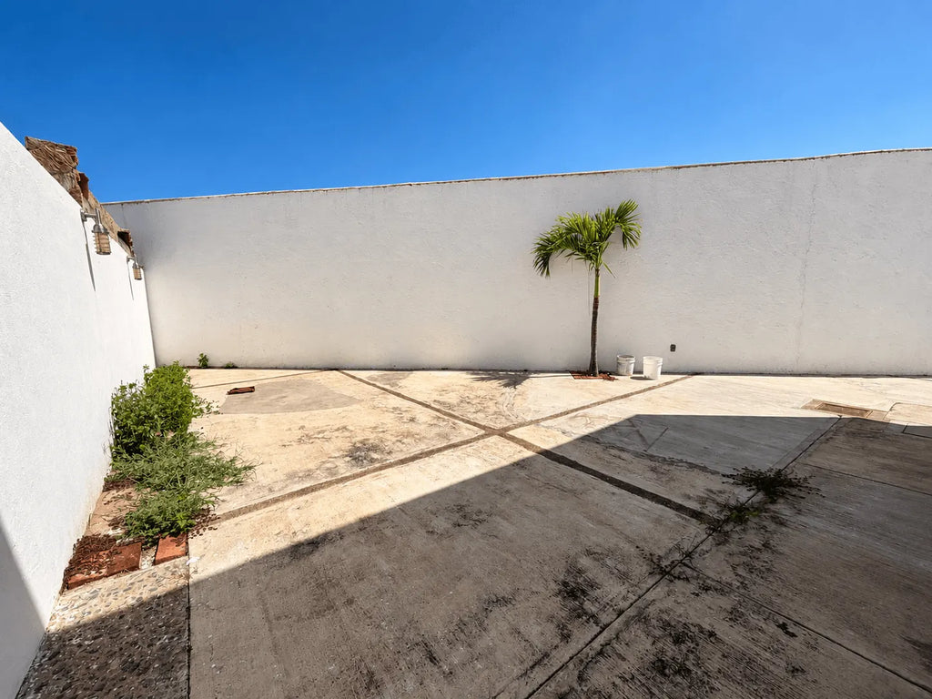 Patio trasero amplio con muro perimetral y área verde