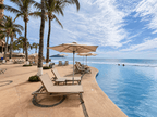 Alberca infinita con camastros y palmeras junto a la playa en Park Royal Mazatlán, Cerritos