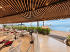 Restaurante con terraza abierta frente a la playa y techo de madera en el edificio Park Royal Mazatlán