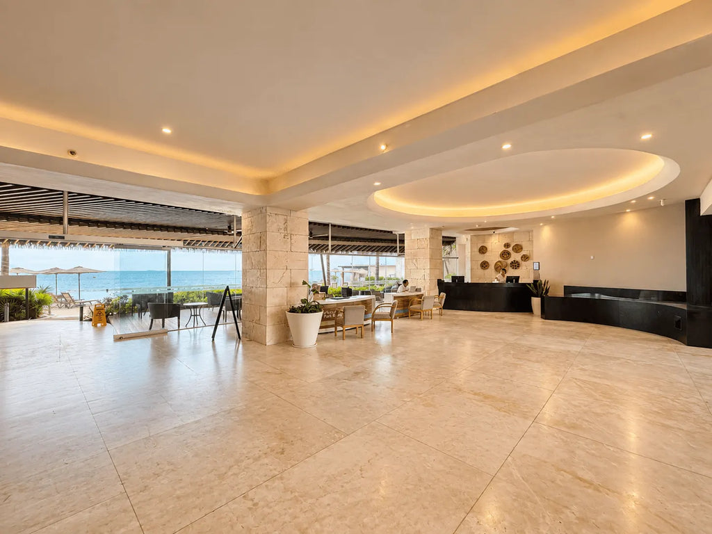 Lobby amplio con piso claro, sala de descanso y acceso a la terraza en el edificio Park Royal Mazatlán