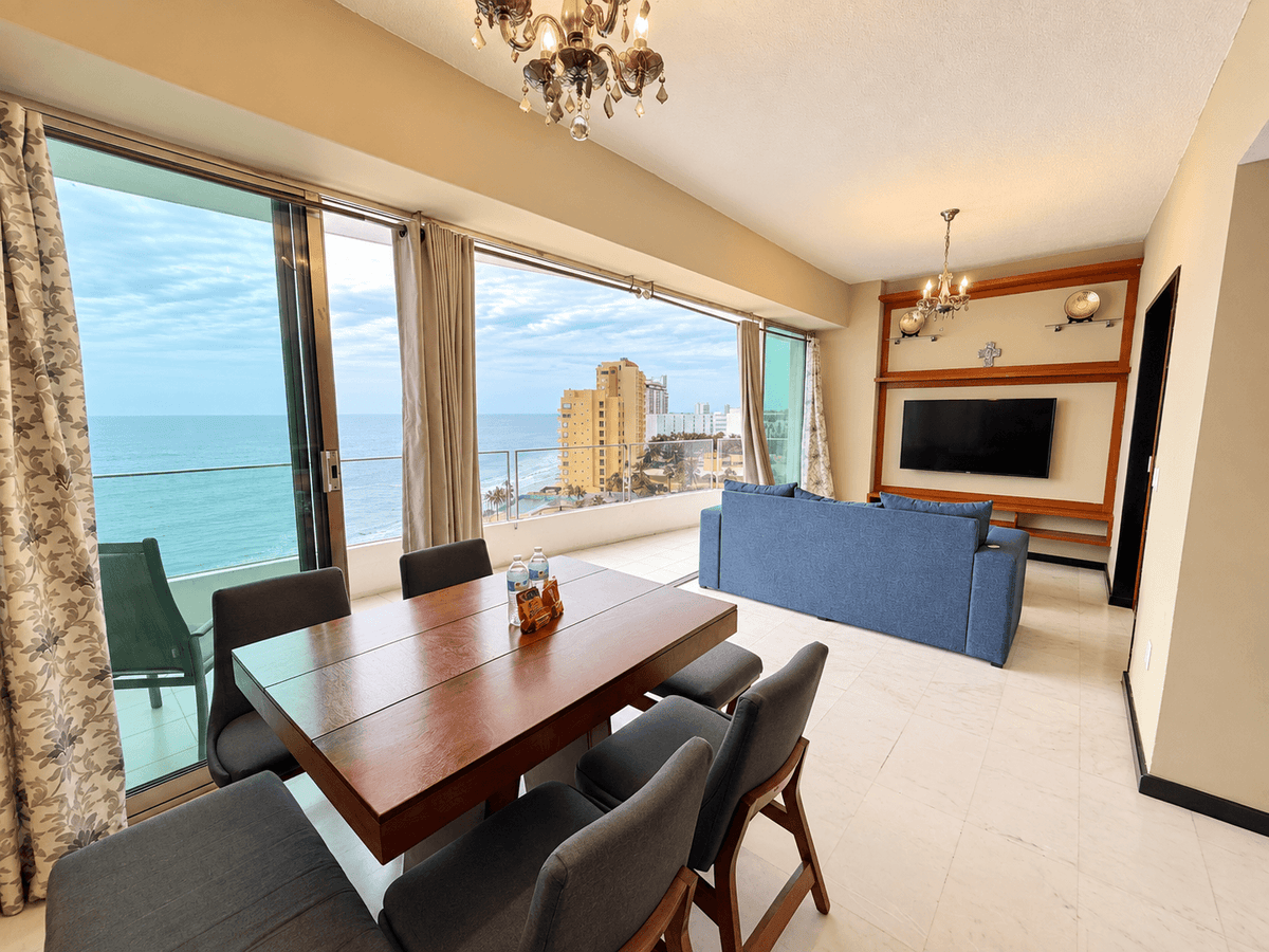 Sala y comedor con ventanales y vista al mar en departamento de esquina en Park Royal Mazatlán
