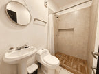 Baño con lavabo de pedestal, WC y regadera con cortina en departamento de 2 baños en venta en Azul Marino