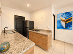Cocina con fregadero, barra de granito y refrigerador en departamento amueblado en venta en Azul Marino