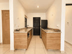 Vista frontal de la cocina equipada con barra de granito y refrigerador en departamento en venta en Cerritos