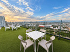 Terraza rooftop con mesas y vista a la ciudad al atardecer, Torre Central 102 Malecón Mazatlán