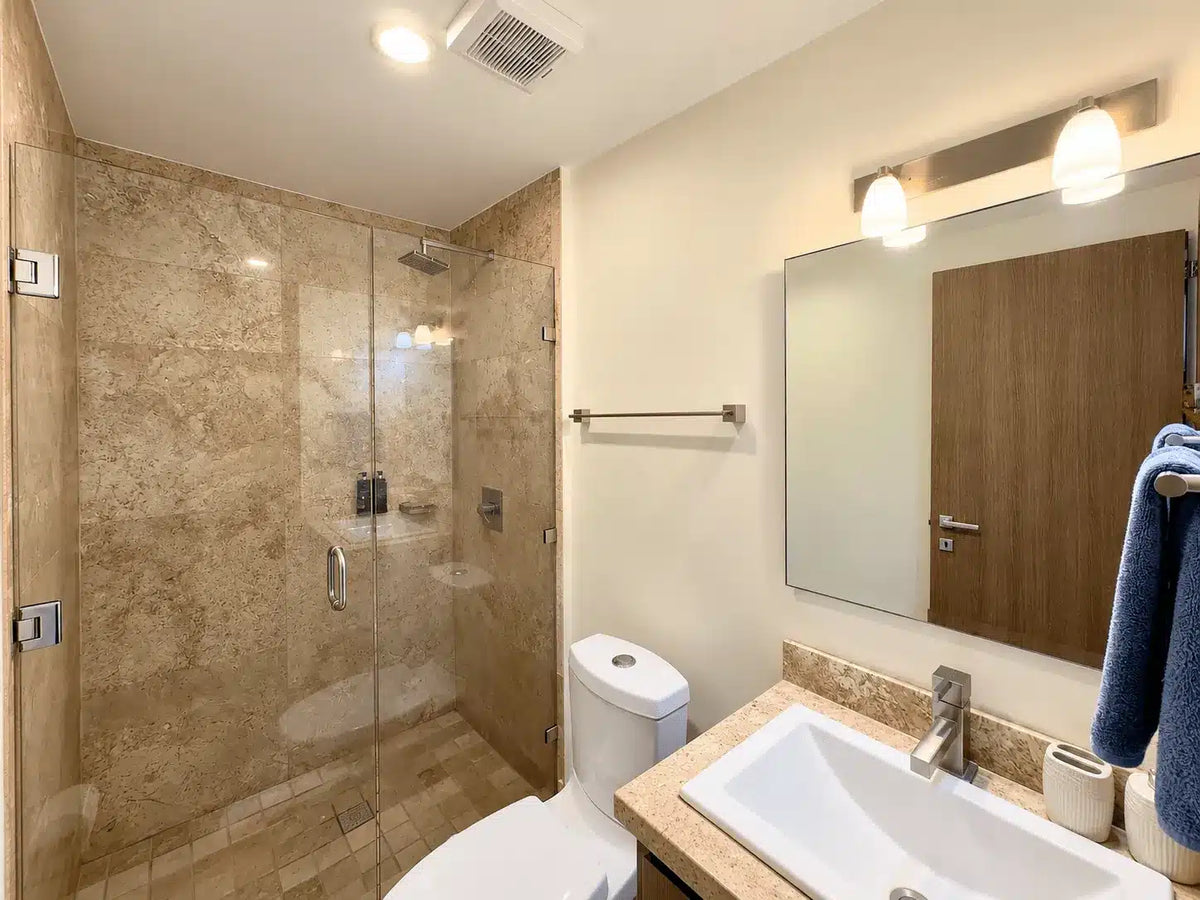 Baño con regadera de cristal y acabados en mármol, Torre Central 102 Mazatlán
