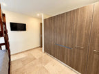 Pasillo con closets de madera y televisión, departamento en Torre Central 102 Mazatlán